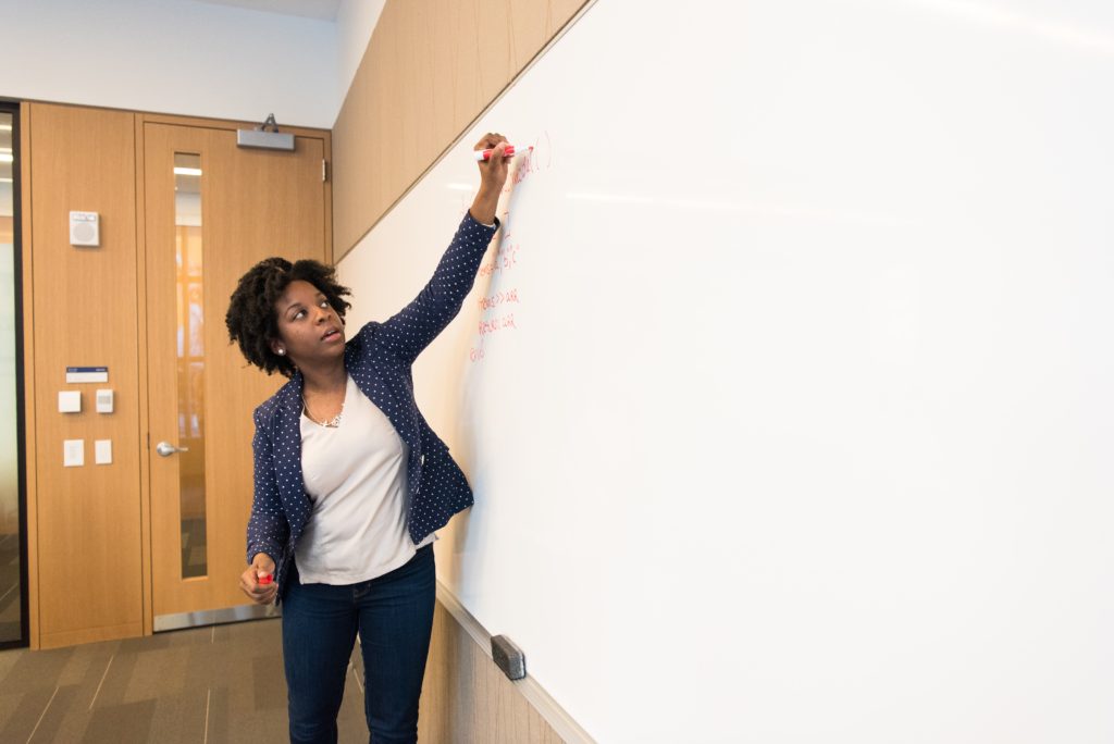 woman-writing-on-dry-erase-board-1181398